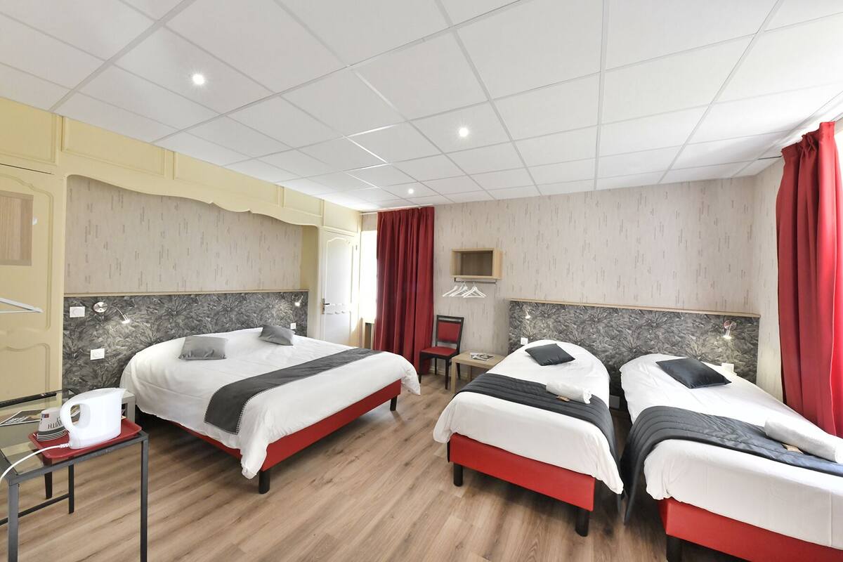 Une chambre d’hôtel avec deux lits, un bureau et une chaise.