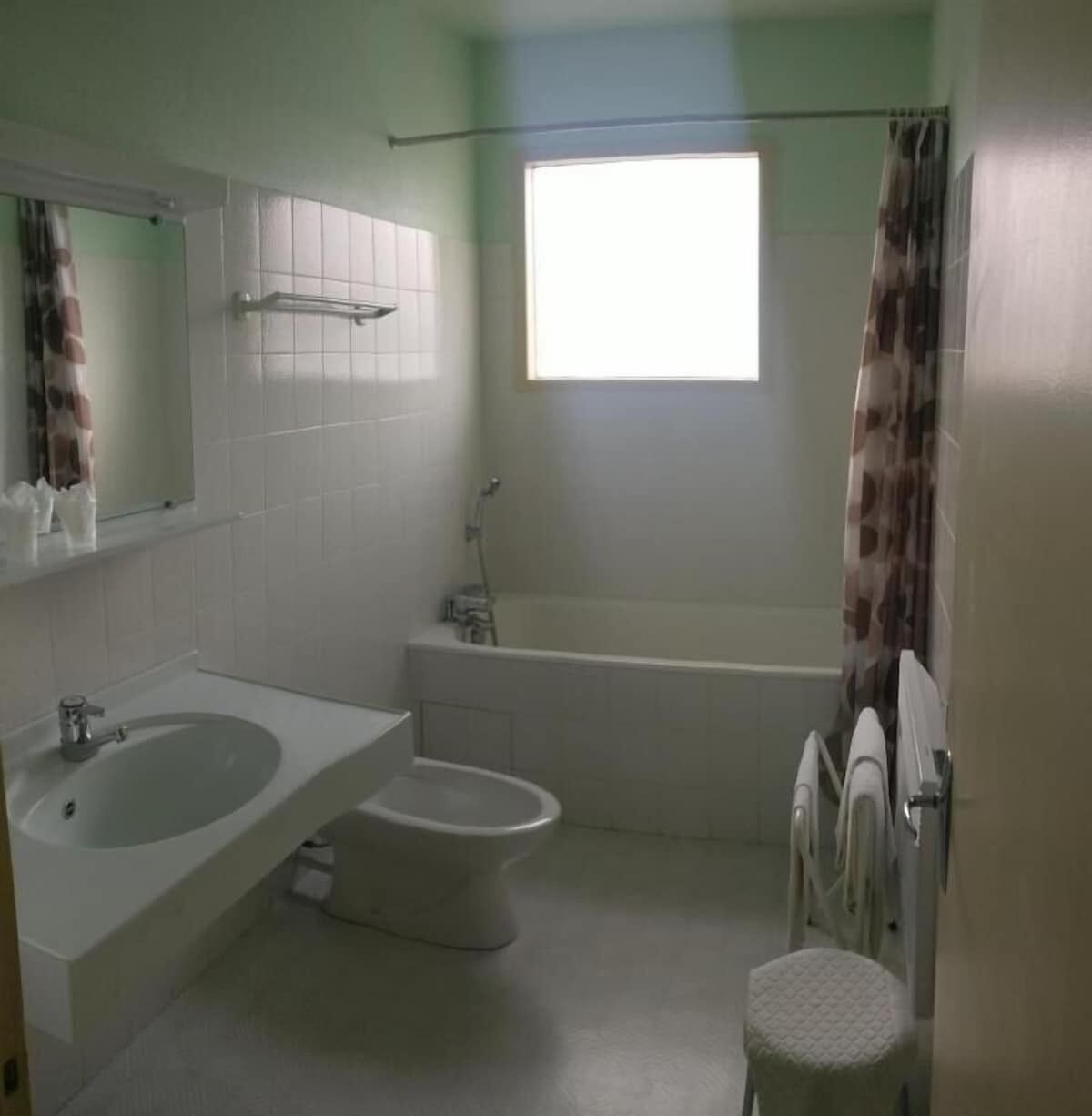 A bathroom with a bathtub, a toilet, and a sink.