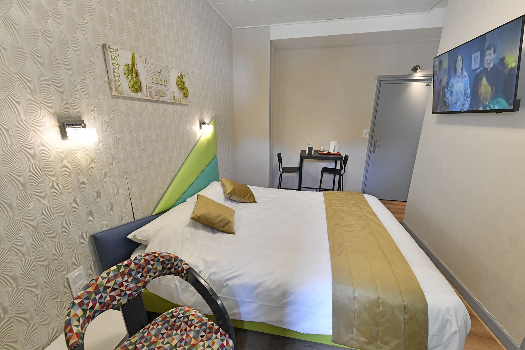 Una habitación de hotel con cama, escritorio y silla.