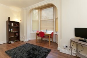 Deluxe appartement, 1 tweepersoonsbed, uitzicht op tuin | Woonruimte | Een flatscreentelevisie