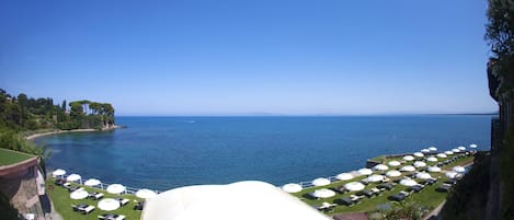 Un complejo turístico frente al mar con terraza al aire libre y vistas al océano.