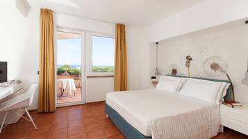 Habitación de hotel con cama, escritorio y vista al exterior.