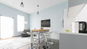 A modern kitchen with a dining area, a coffee machine, and a radiator. - Primeflats - Apartment Weissensee (Berlin)