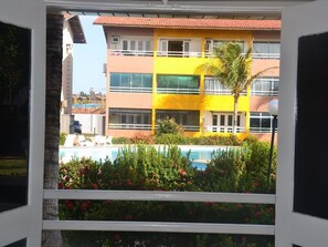 A multi-story building with a pool in the foreground. - Village Van Cartier - MeuLugarCeará (Fortaleza)