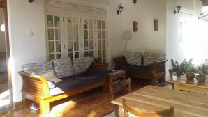 Un saló acollidor amb un sofà, una taula de fusta i zona de menjador.