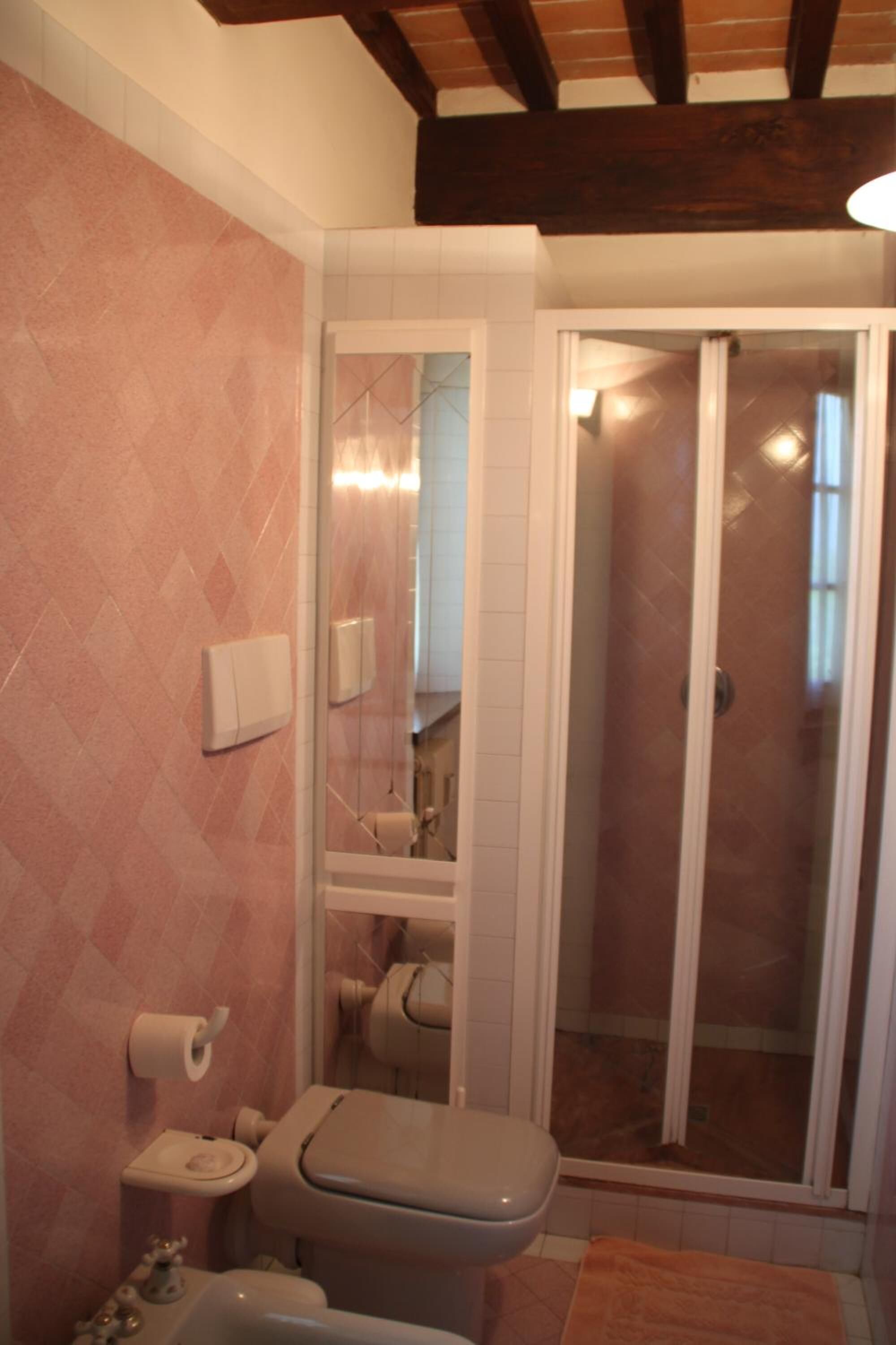 A bathroom with a toilet, sink, and shower area.
