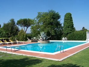 Una piscina al aire libre de temporada, sillones reclinables de piscina