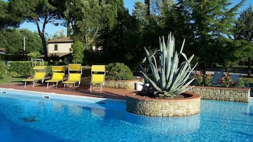 Una piscina al aire libre de temporada, sillones reclinables de piscina