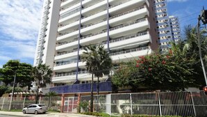 Un hôtel à plusieurs étages doté de balcons, d’un parking et d’un jardin clos.