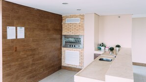Une cuisine équipée d’un four encastré, d’un évier et d’un mur en bois.