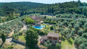 An aerial view of a countryside property with a swimming pool, stone buildings, and olive groves. - Tenuta La Pieve Casale La Valle (Pergine Valdarno)