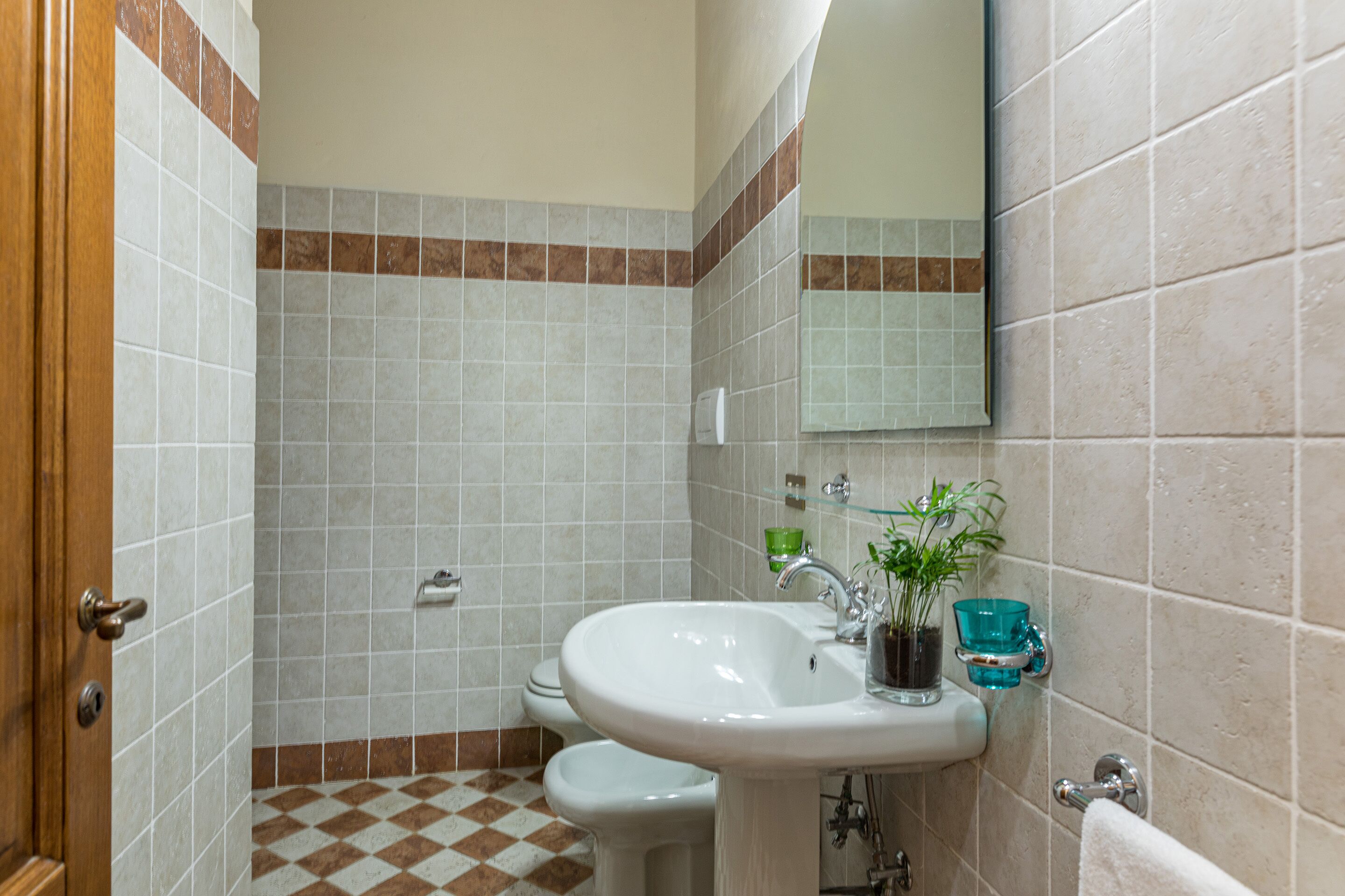 A bathroom with a sink, mirror, and toilet.