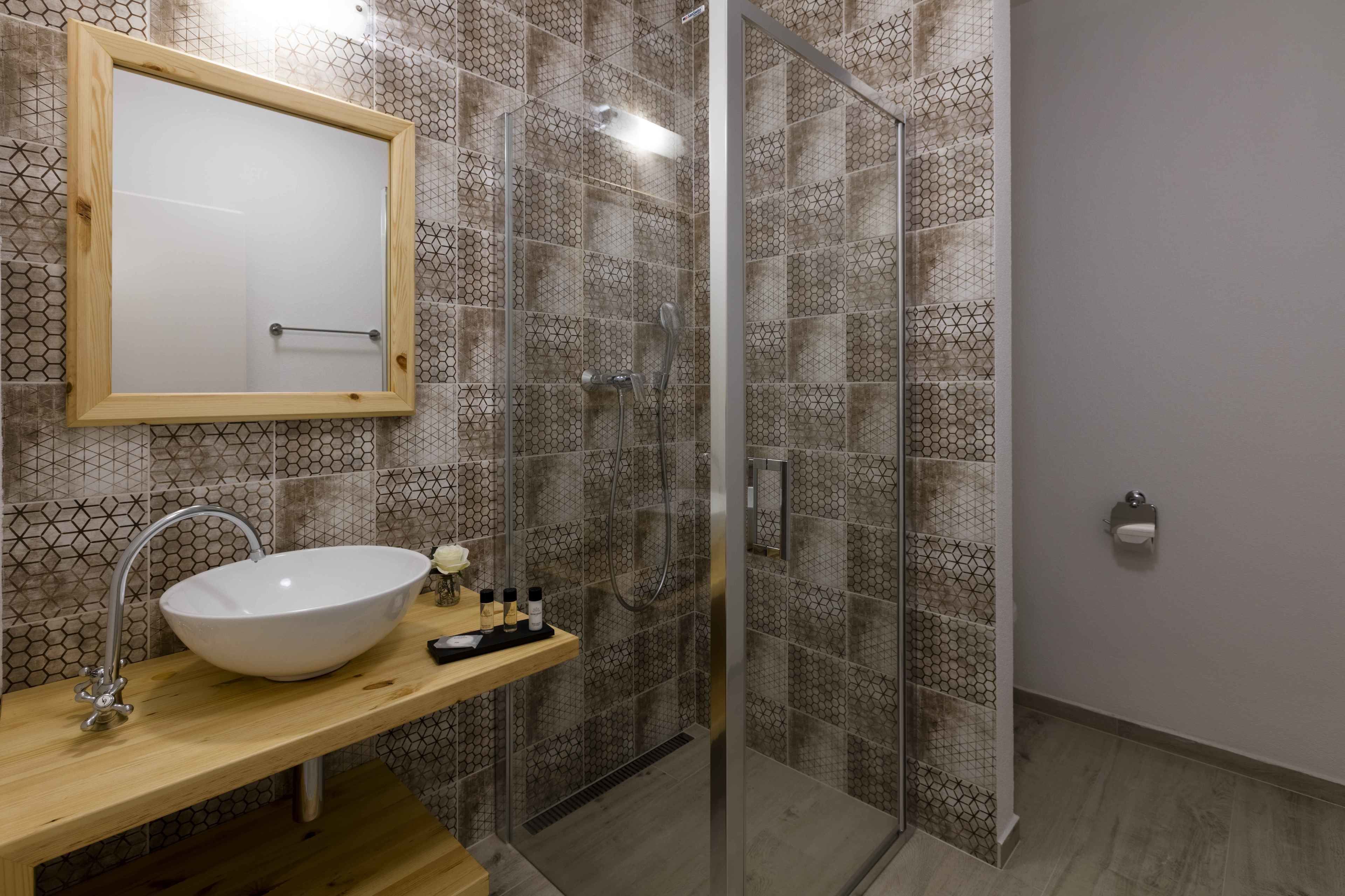 A modern bathroom with a glass-enclosed shower, a wooden vanity with a white vessel sink, and a mirror above the sink.