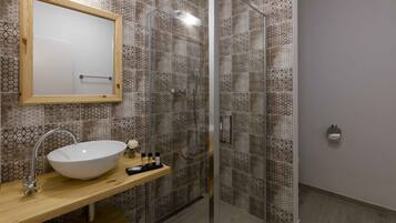 A modern bathroom with a glass-enclosed shower, a wooden vanity with a white vessel sink, and a mirror above the sink.