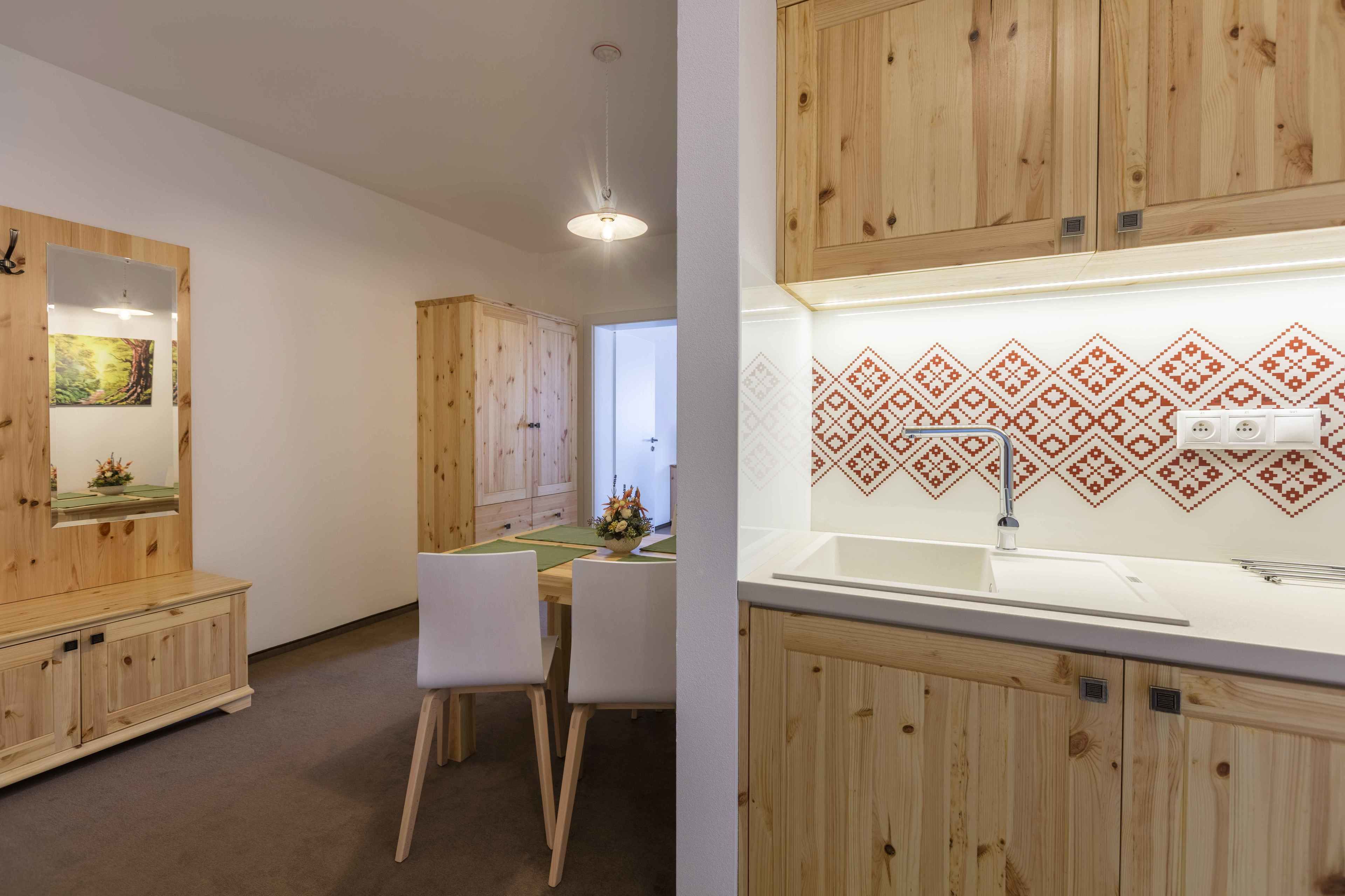 Una cocina moderna con armarios de madera, encimera blanca y salpicadero con diseño.