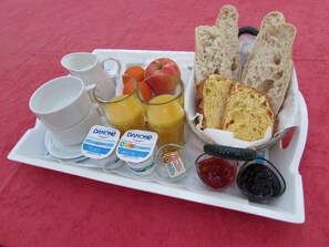 A breakfast tray with Danone yogurt, orange juice, bread, and jam. - Royal Palmeraie (Aubagne)