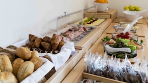 Un bufé con diversas opciones de comida, incluyendo pasteles, carnes y frutas.