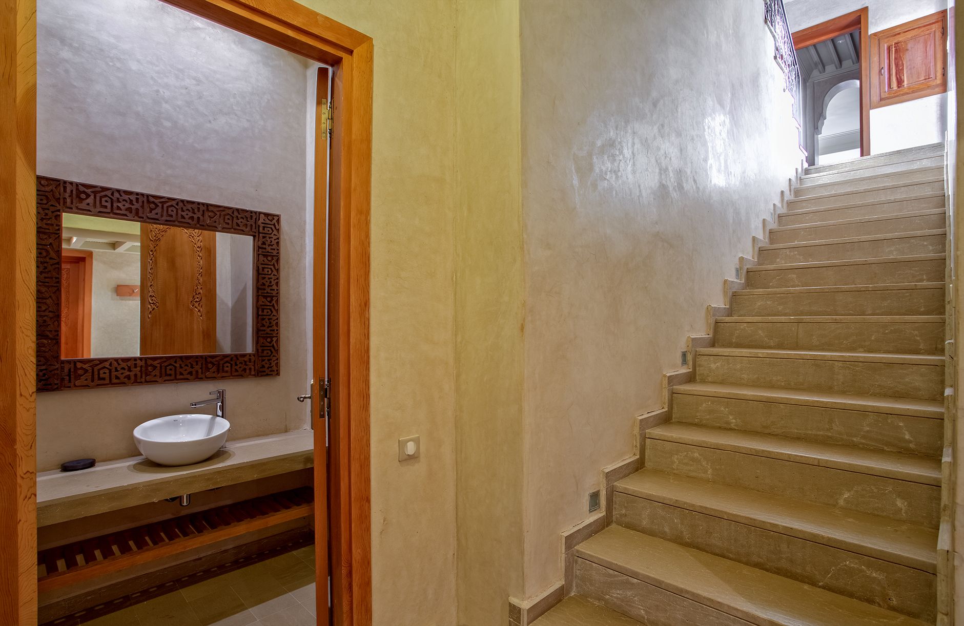 A bathroom with a sink, mirror, and wooden door frame.