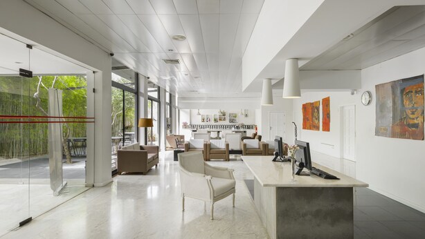 A spacious, modern interior with a reception desk, seating area, and artwork on the walls. - Hotel Umu (Santarém)