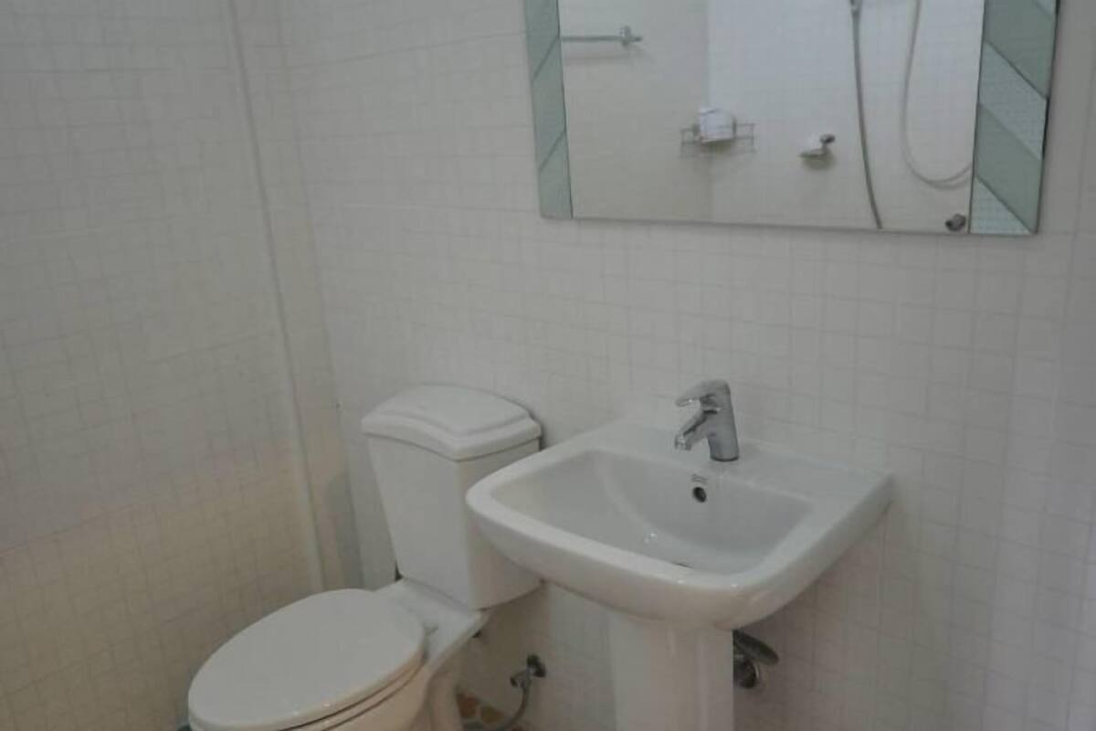 A bathroom with a toilet, a sink, and a mirror.
