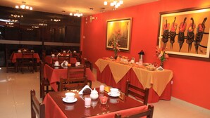 A restaurant with tables set for dining, featuring a red and beige color scheme. - Peru Hosting Piura (Piura)