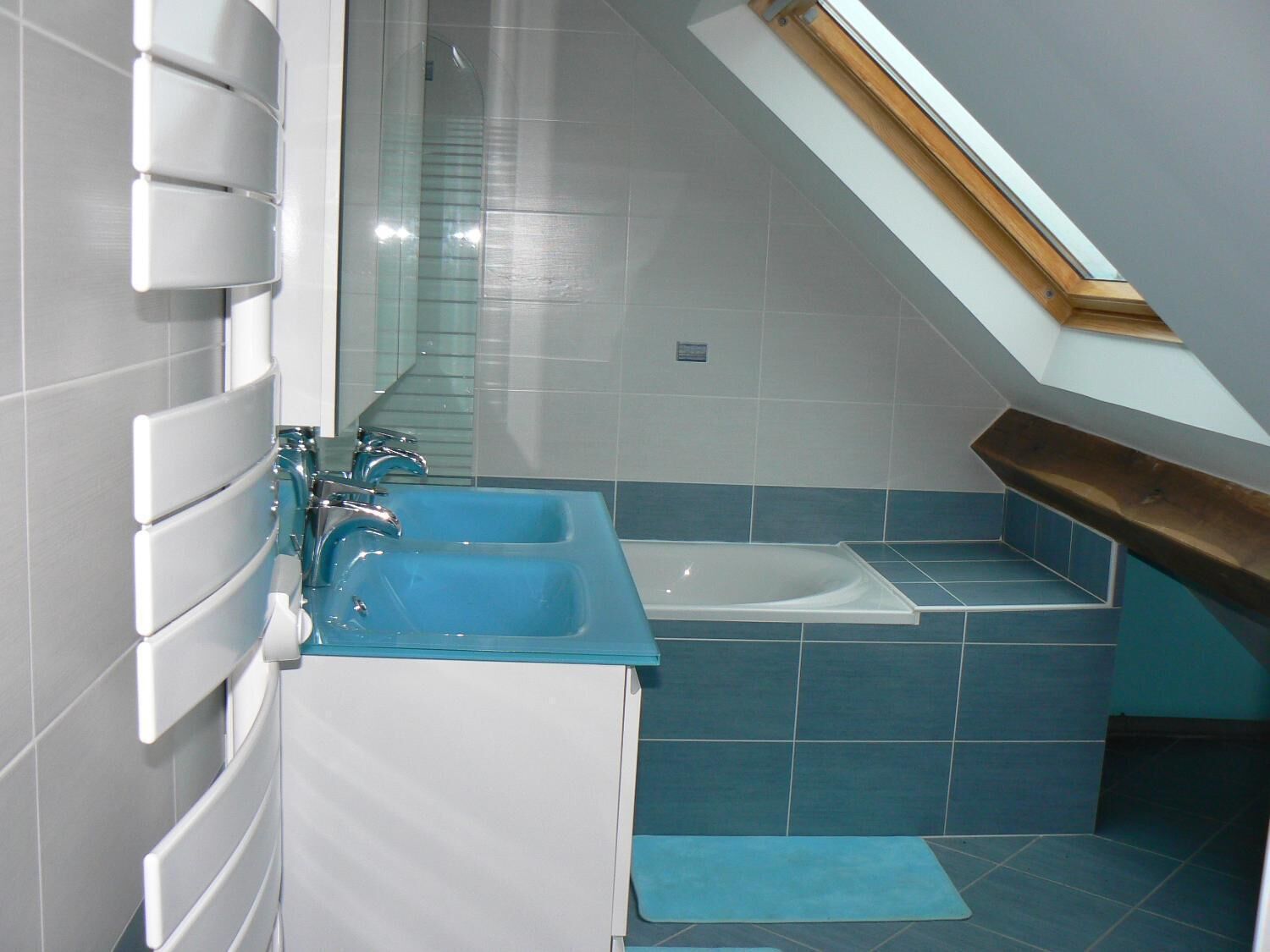 Un baño con tragaluz, bañera y lavamanos.