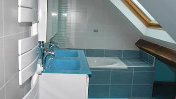 Un baño con tragaluz, bañera y lavamanos.