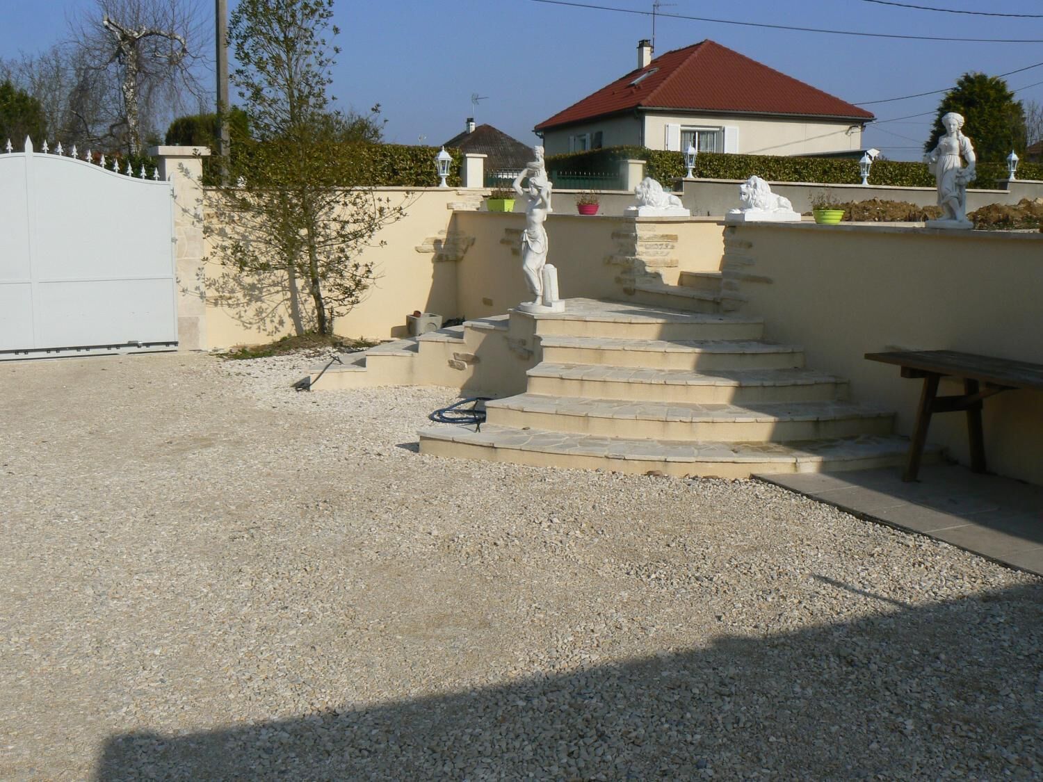 Un barrio residencial con una casa, una valla blanca y una escalera de piedra que lleva a una puerta.
