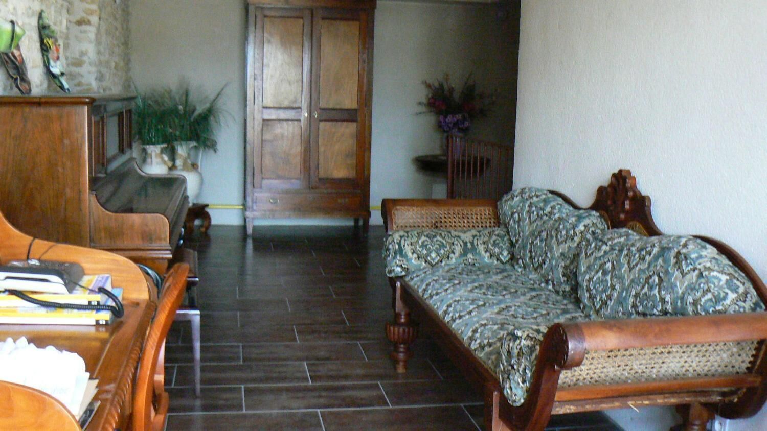 Una sala de estar con un sofá, un mueble de madera y un piano.