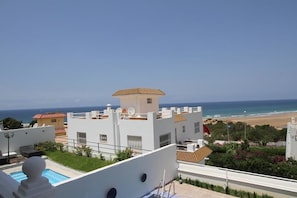 A white building with a rooftop pool and a view of the beach. - Villa Tanger Cap Spartel (Tangier)