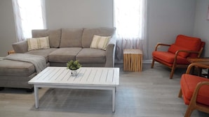 Ein Wohnzimmer mit einer Eckcouch, einem Couchtisch und zwei Sesseln.
