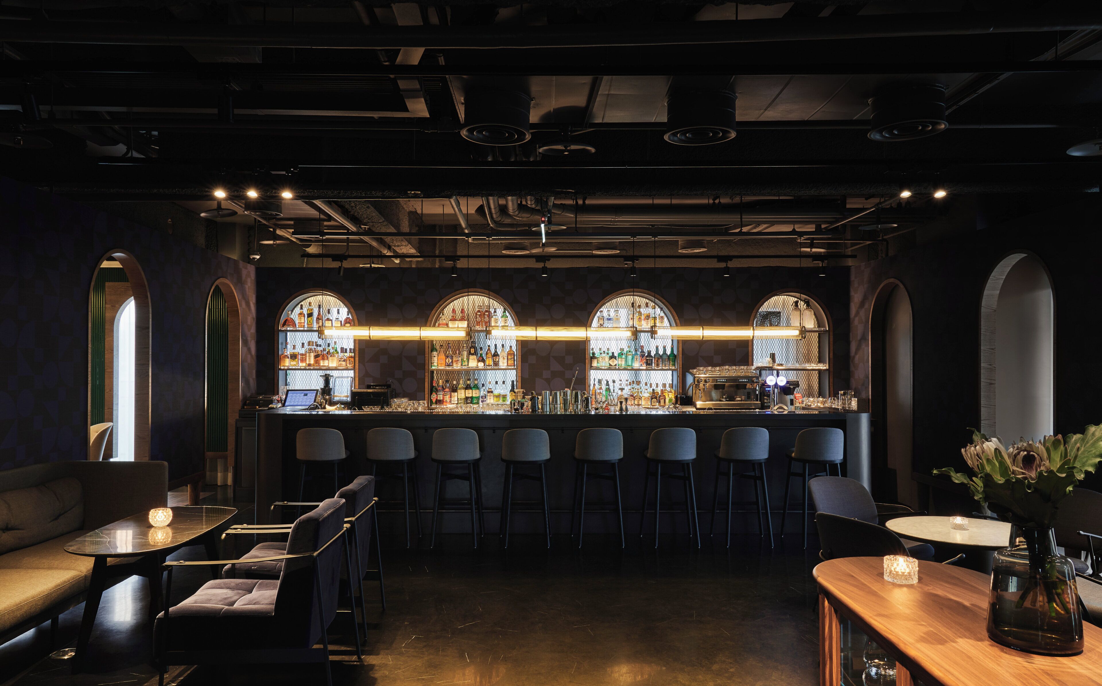 A bar area with a counter, bar stools, and seating.