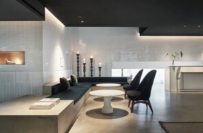 A modern interior with a seating area, a dining table, and a kitchen in the background. - Kimpton Da an Taipei by IHG (Taipei)