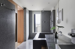 Een moderne badkamer met een groot raam, een douche en een wastafel.