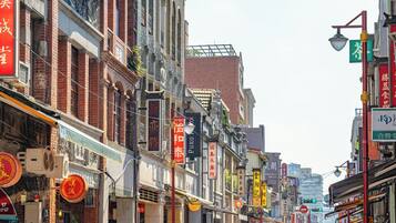 A street lined with traditional buildings, some with signage in a foreign script, and a mix of architectural styles.