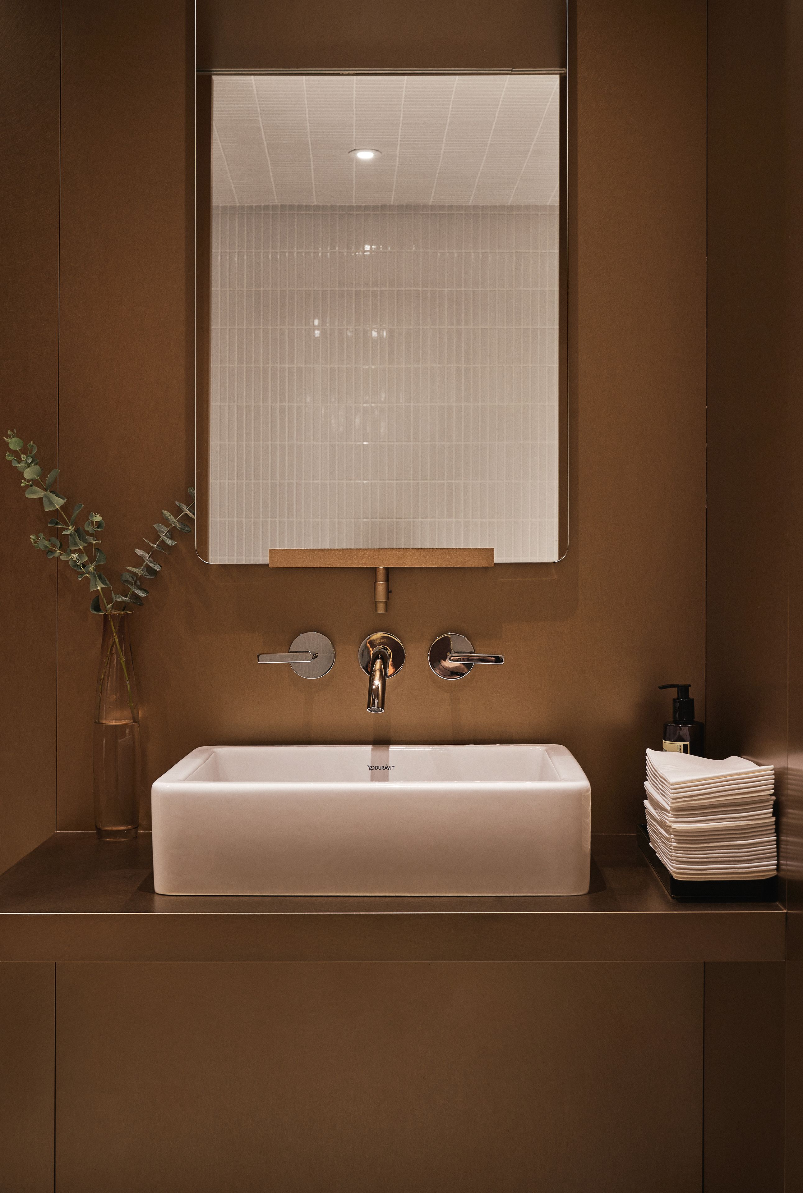 A modern bathroom with a rectangular sink, a mirror, and a faucet.