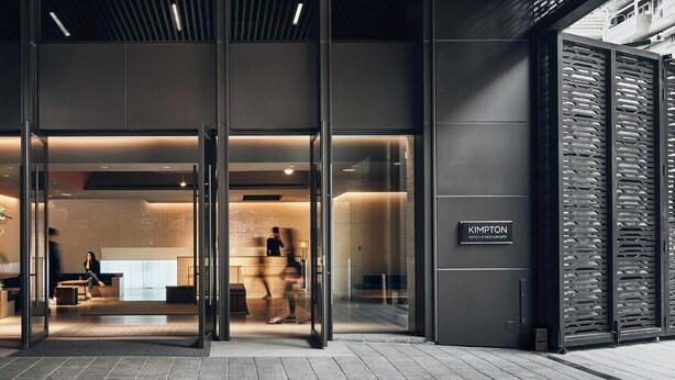 A modern hotel entrance with a glass door, indoor seating area, and a visible sign for 'KIMPTON Hotels & Restaurant'. - Kimpton Da an Taipei by IHG (Taipei)