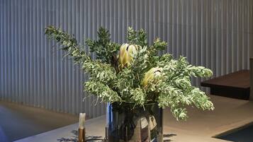 Een receptiebalie met een potplant, kaarsen en een boek getiteld 'Echo2'.