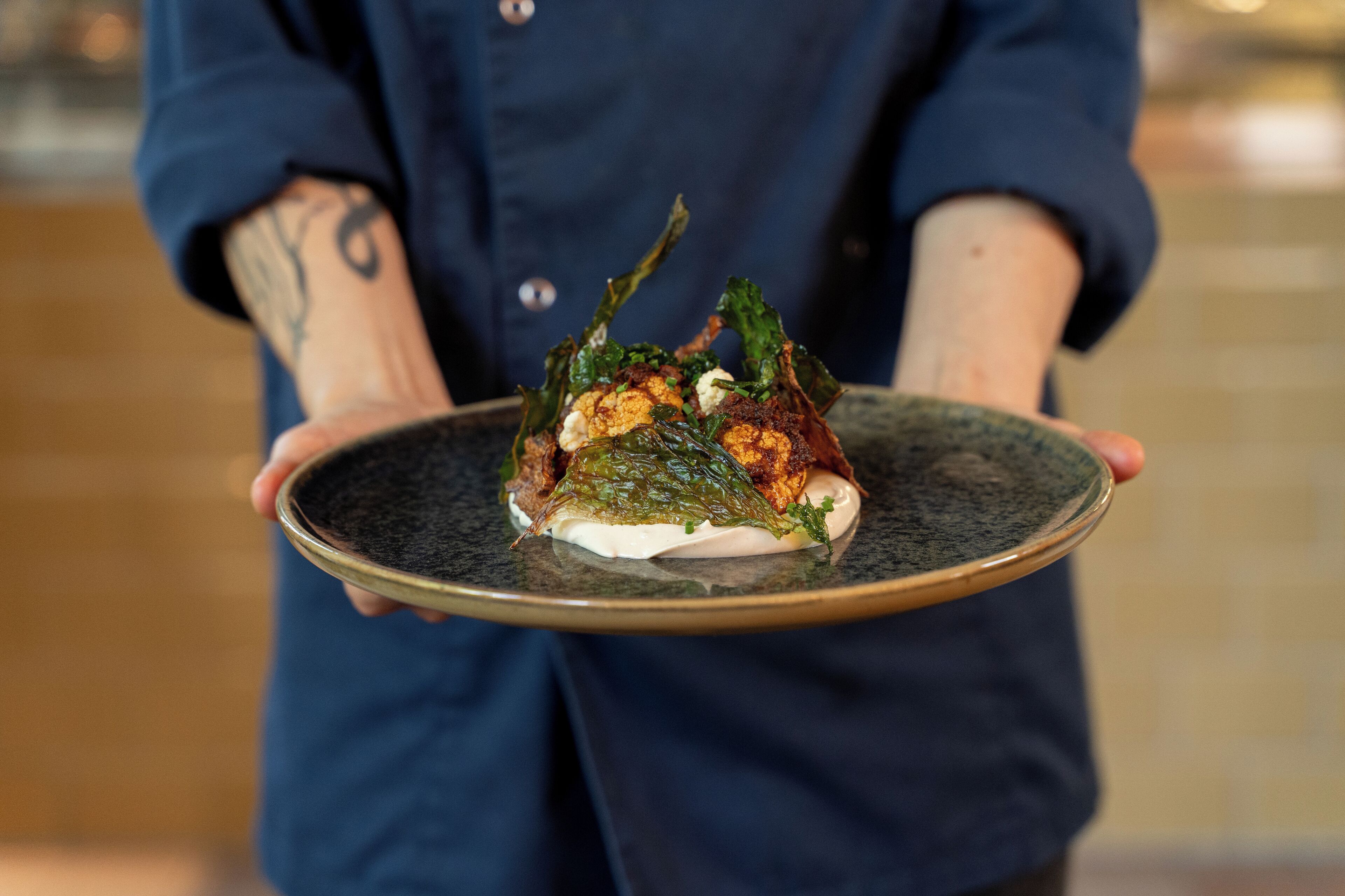 A person holding a plate with a food dish.