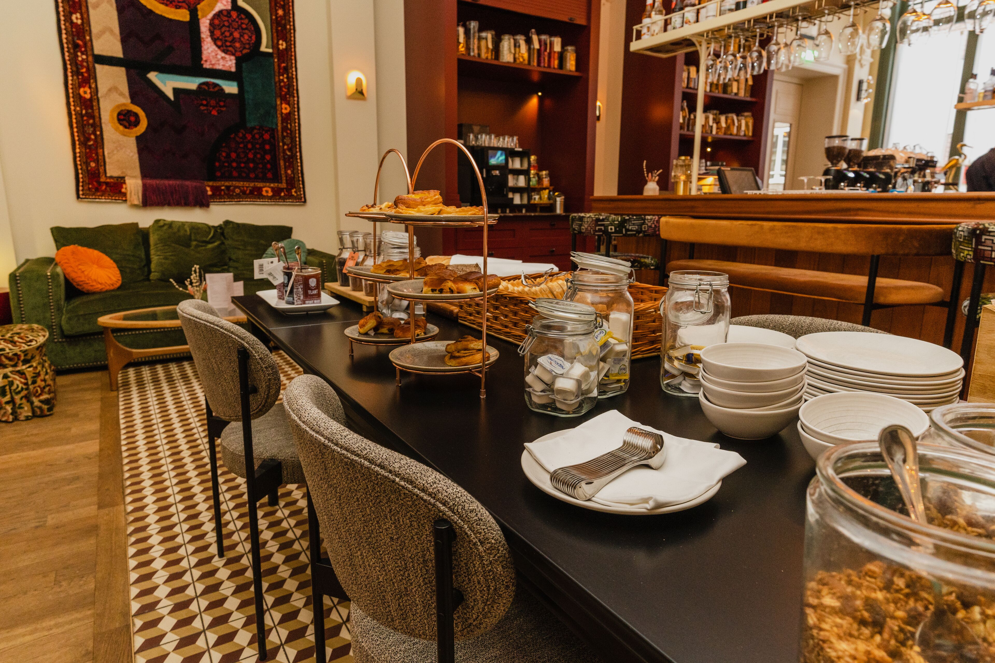 A breakfast buffet with various pastries, bread, and condiments.