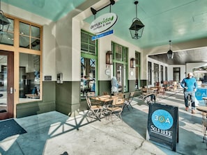 An outdoor seating area with tables and chairs, a sign for 'amavida coffee & tea', and a '30A sold here' sign.