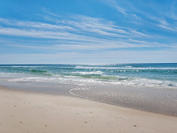 Enjoy a serene beach experience with gentle waves lapping at the shore.