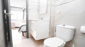 A modern bathroom with a toilet, sink, and cabinet. - Pension Caldas (Caldas de Reis)