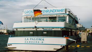 A boat named 'LA PALOMA Hamburg-D' with 'GROSSENRUNDFAHRT' written on the upper deck.