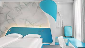 Een moderne hotelkamer met een groot bed, een bureau en een koffer.