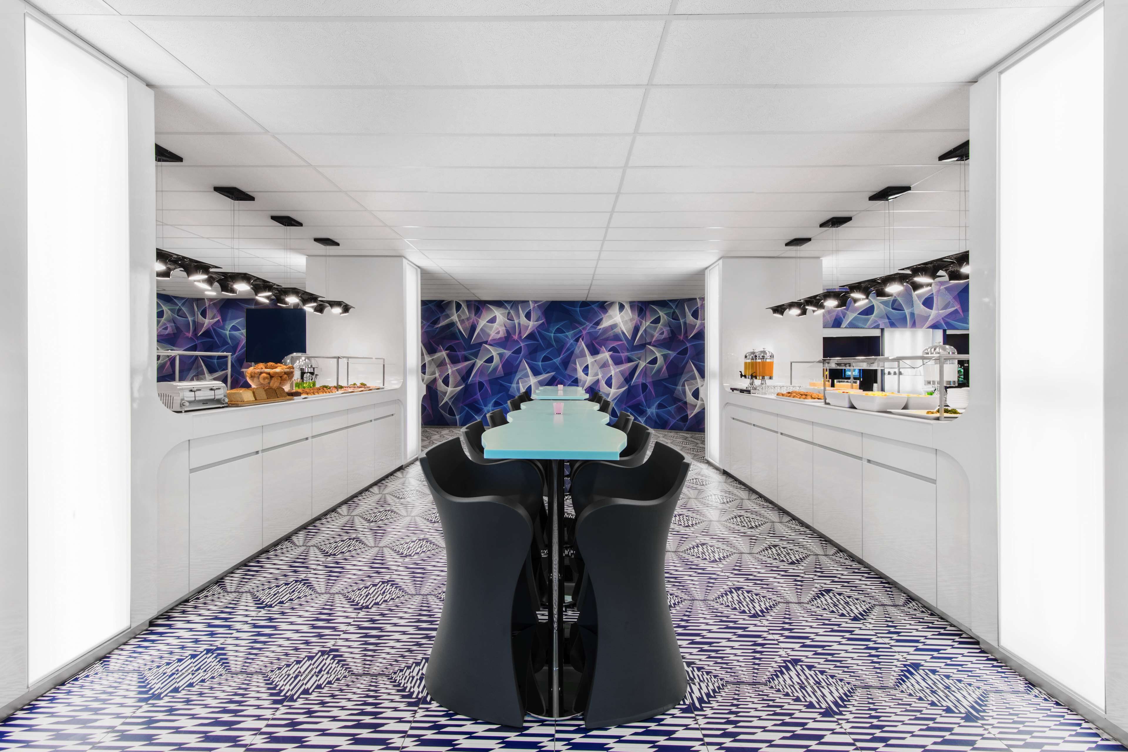 Une cuisine moderne dotée d’un îlot central, de meubles blancs et d’un sol à motifs.