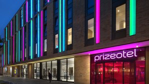 A building with a modern design, featuring a glass facade and neon signage.