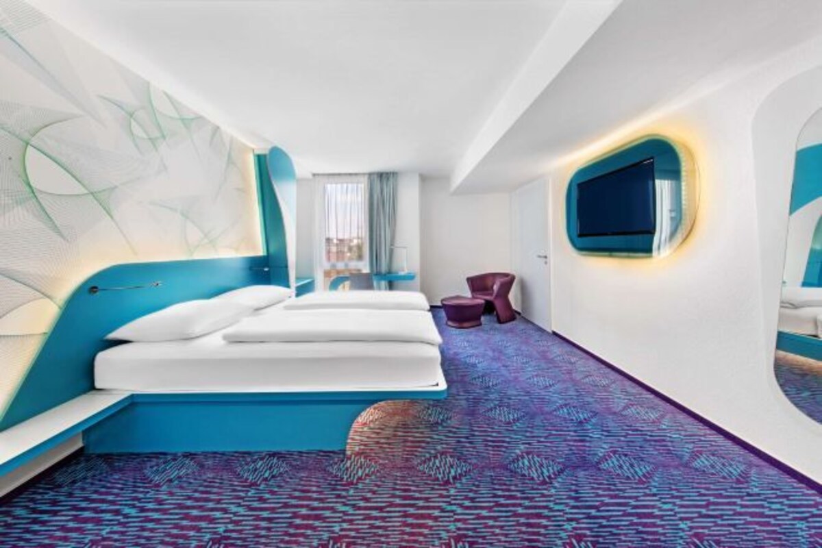 Een moderne hotelkamer met een groot bed, een zithoek en een televisie.