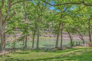 A natural setting with trees, a body of water, and a picnic area. - RR 8554 Blue Paradise (New Braunfels)