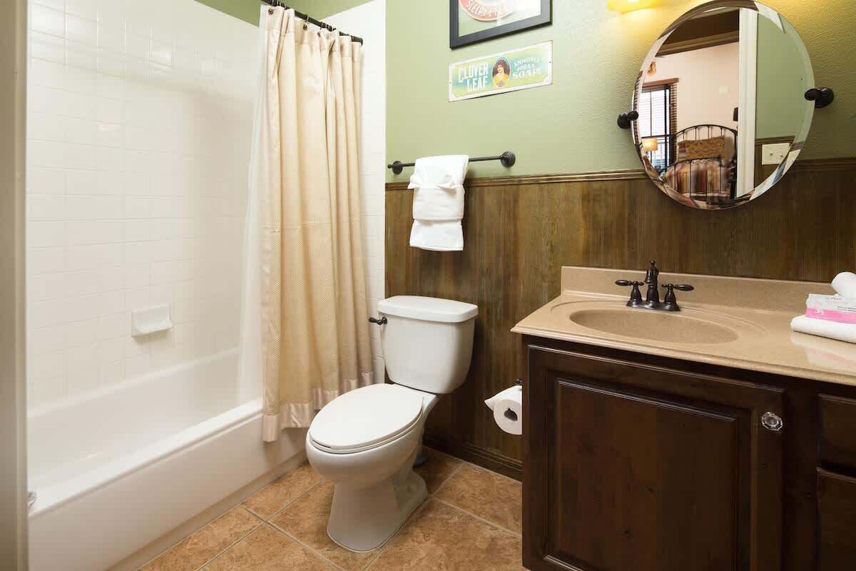 A bathroom with a bathtub, toilet, sink, and a mirror.